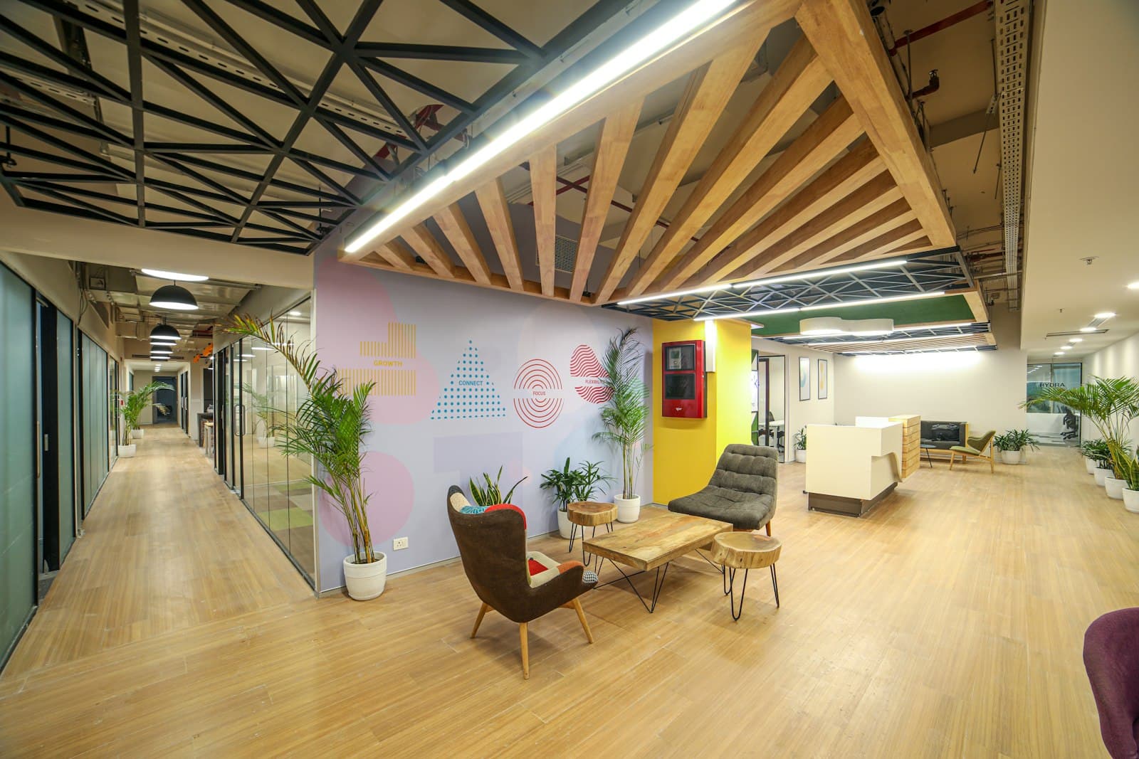 Office entrance lounge with a white reception desk, timber floor, slatted timber ceiling, armchairs and potted palms